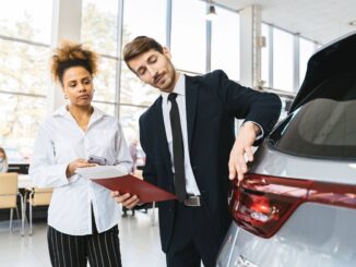Professionnels examinent un véhicule dans un showroom lumineux