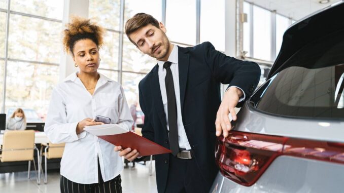 Professionnels examinent un véhicule dans un showroom lumineux