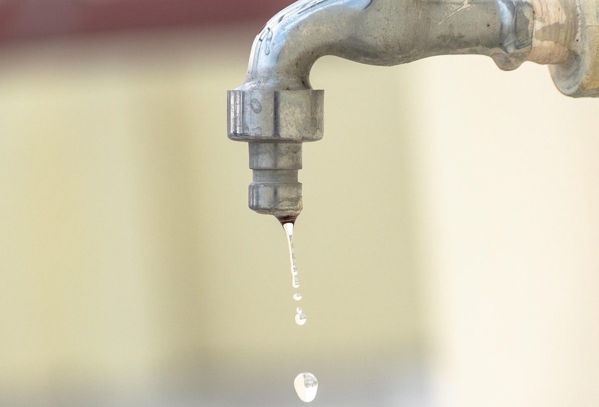 Goutte d'eau qui se détache du robinet usé Goutte d'eau qui se détache du robinet usé