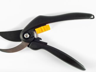 Un secateur de jardinage à main noir avec levier jaune posé